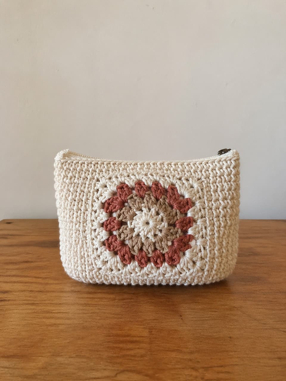 Real handmade zip pouch on a wooden table, used as a fidelity-safe accessory example